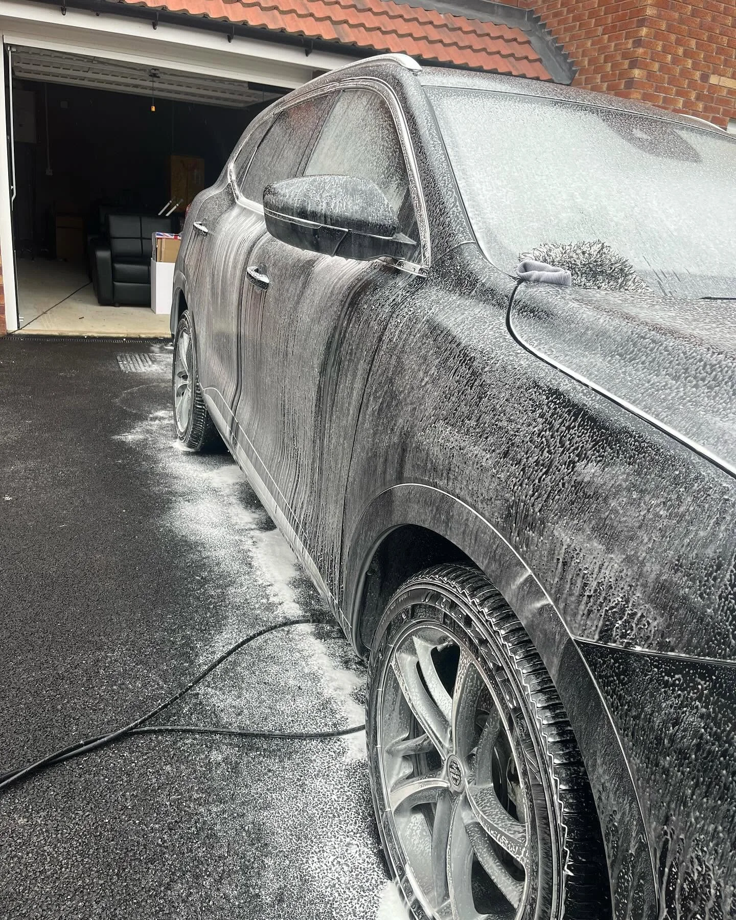 A vehicle being snow foamed during a mobile valet