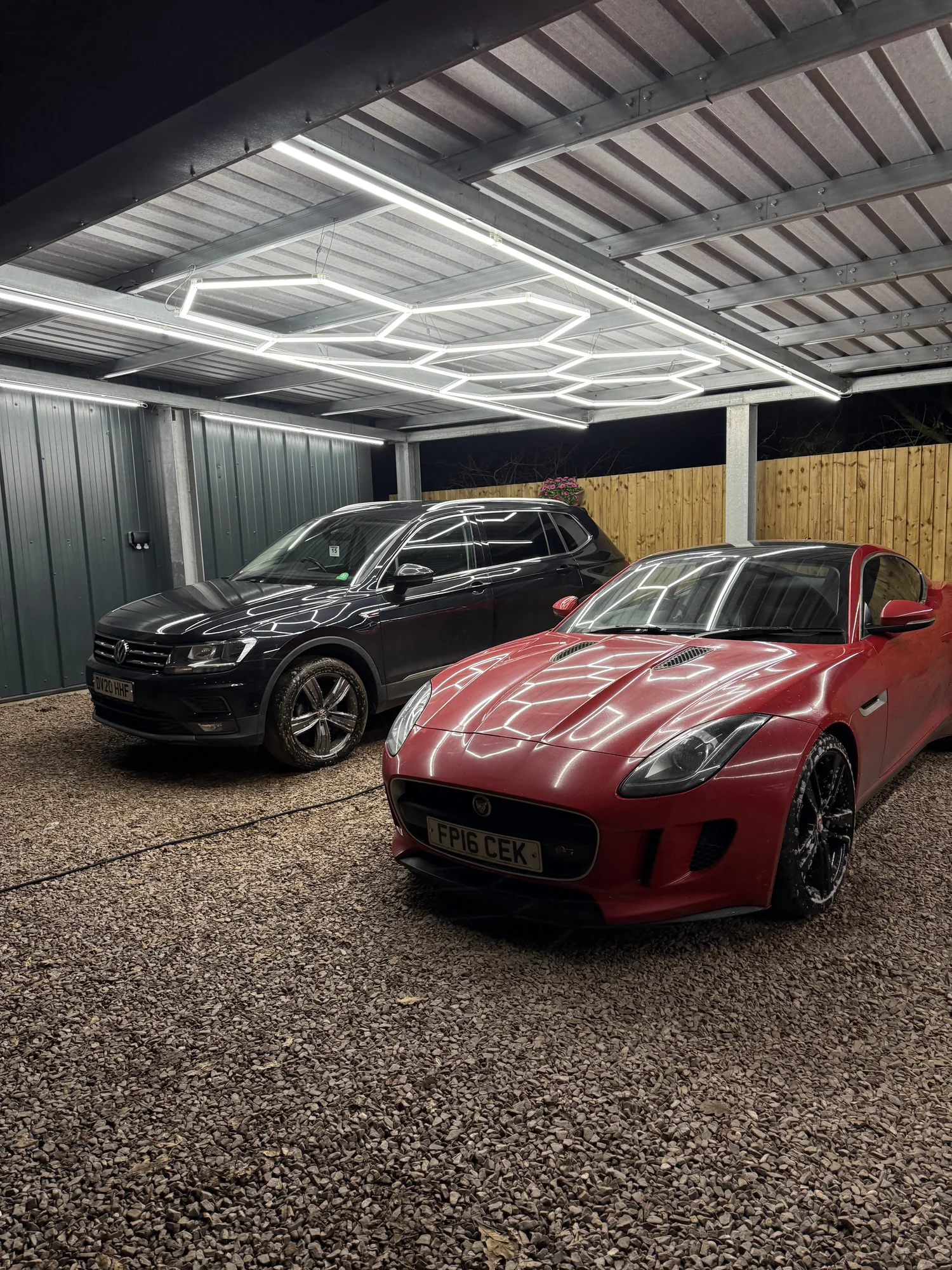 Two freshly cleaned vehicles beneath professional detailing lights