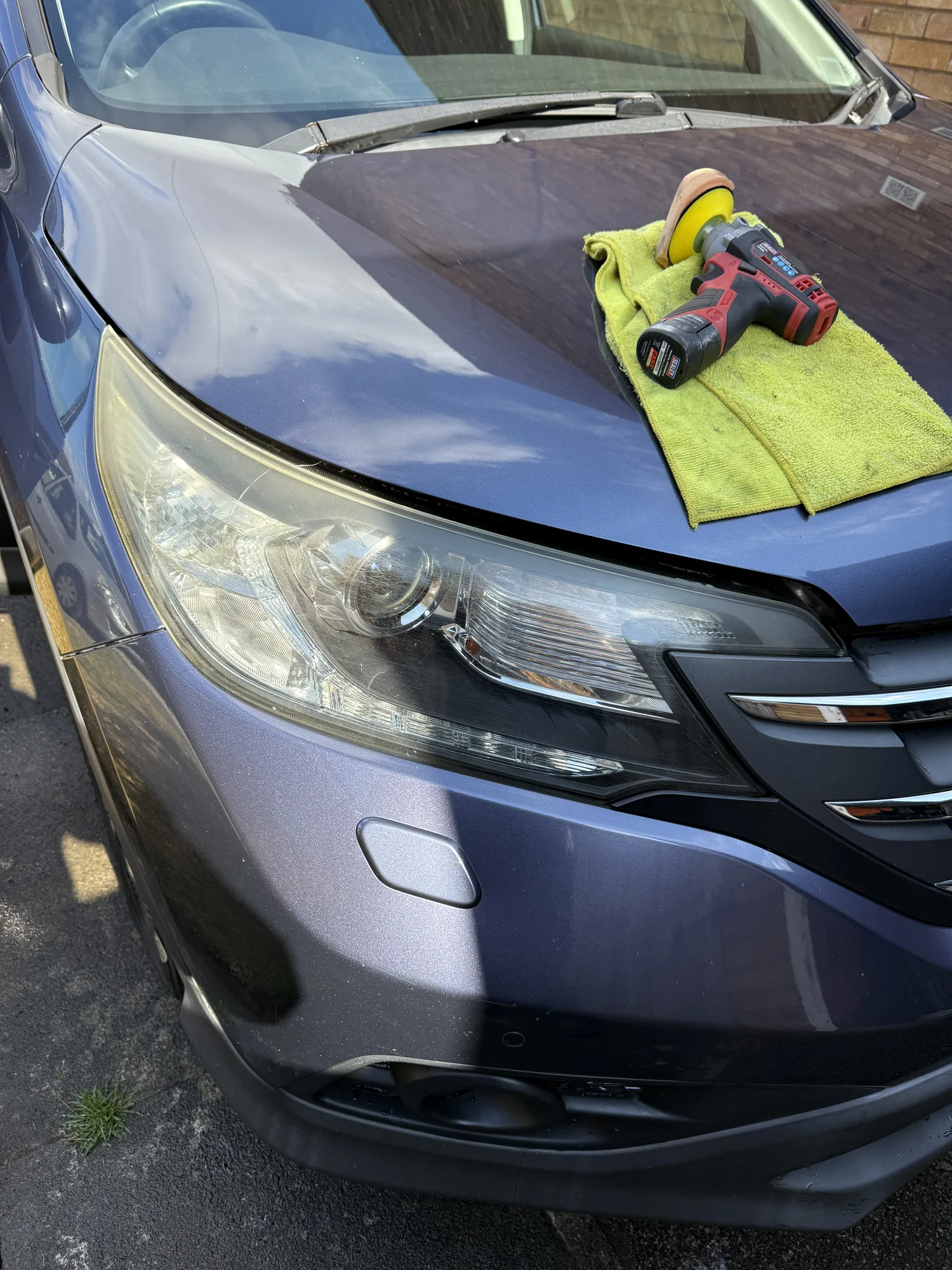 Professional machine polisher and microfibre cloth placed on a car bonnet