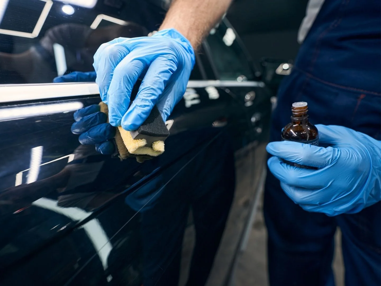 Ceramic coating being applied to black vehicle paintwork